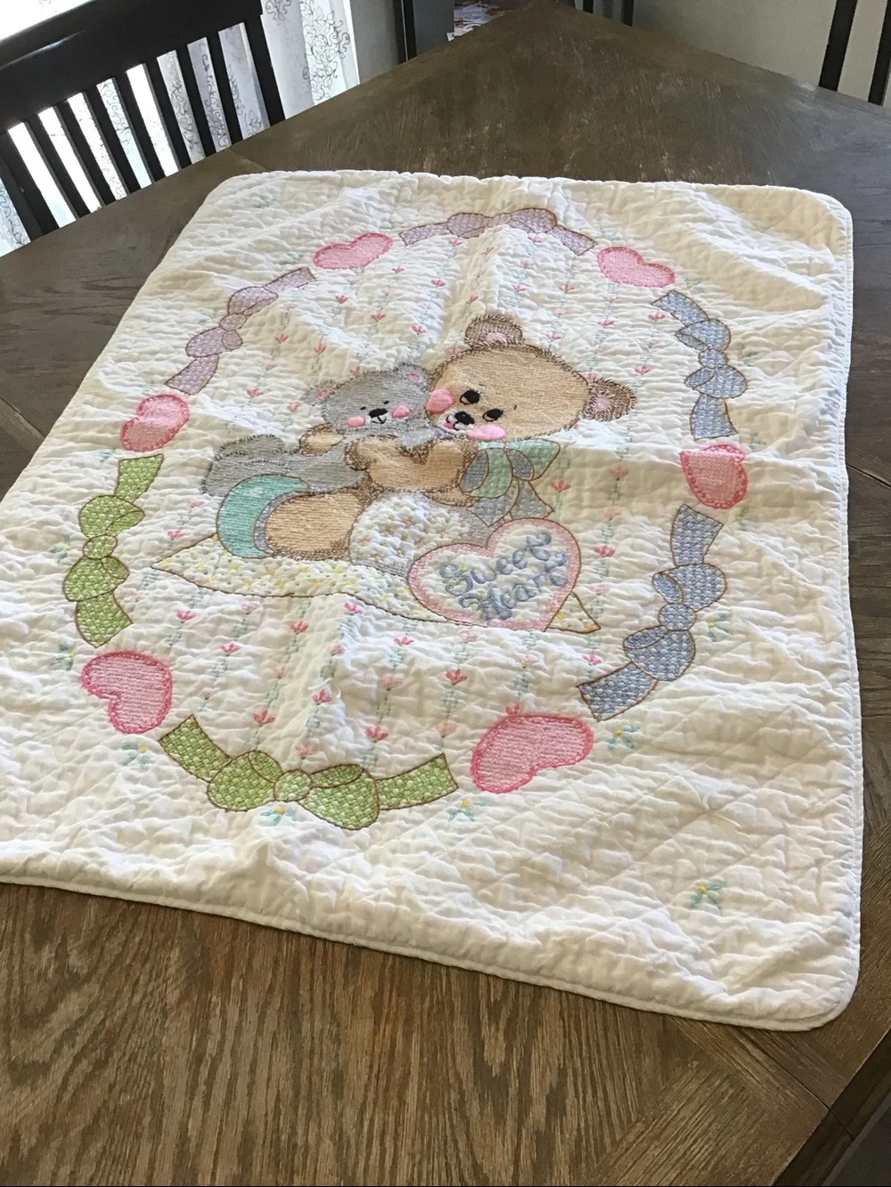 Vintage handmade baby quilt featuring embroidered teddy bears